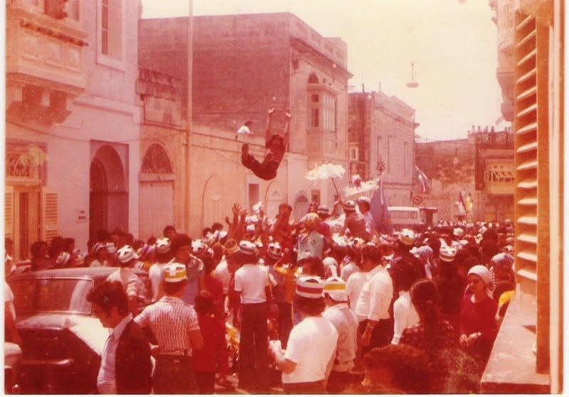 A crowd in a decorated village street