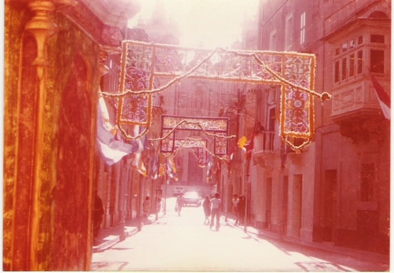 A street decorated with flags and lights