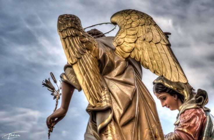 A view of the angel’s gold wings and Mary’s statue