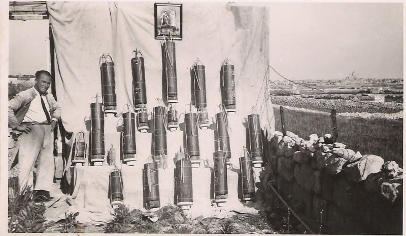 A man beside a display of cylindrical objects