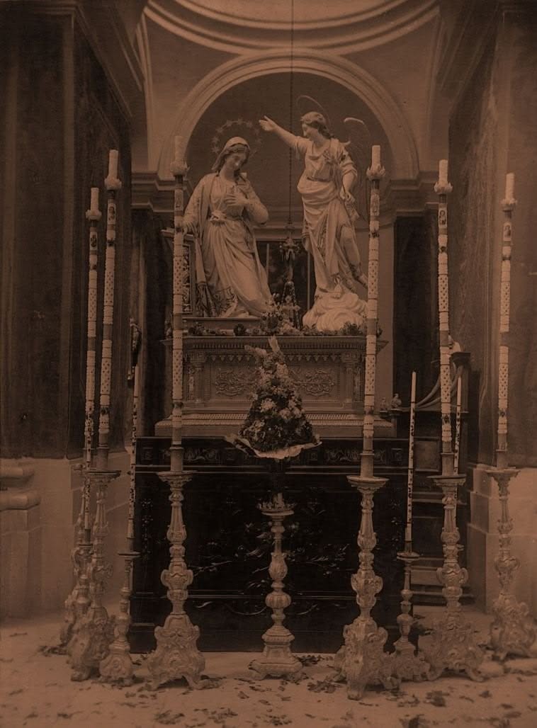 Annunciation statues surrounded by candles